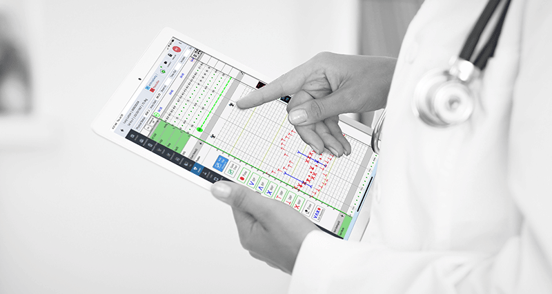 Anesthesiologist Using iPro AIMS Vitals Chart Clinician holding iPro AIMS and using the vitals chart