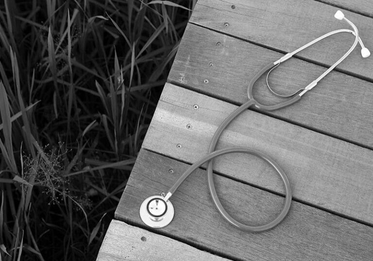 Stethoscope on wooden deck over grass