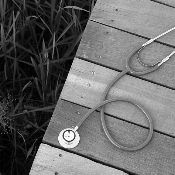 Stethoscope on wooden deck over grass